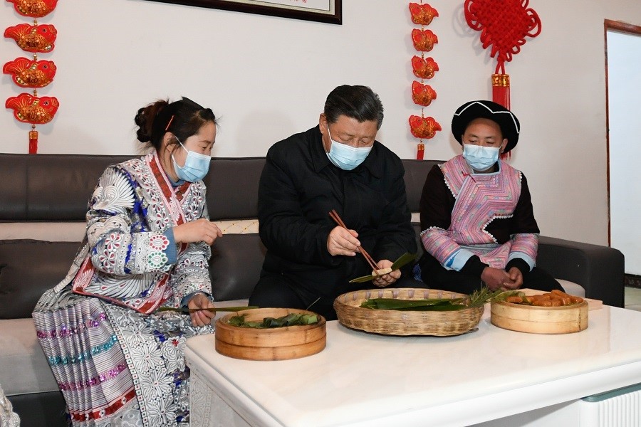 2021年2月3日下午，習(xí)近平在貴州畢節(jié)市黔西縣新仁苗族鄉(xiāng)化屋村苗族村民趙玉學(xué)家，同一家人邊聊家常邊制作當(dāng)?shù)貍鹘y(tǒng)節(jié)日食品黃粑。新華社記者 李學(xué)仁 攝
