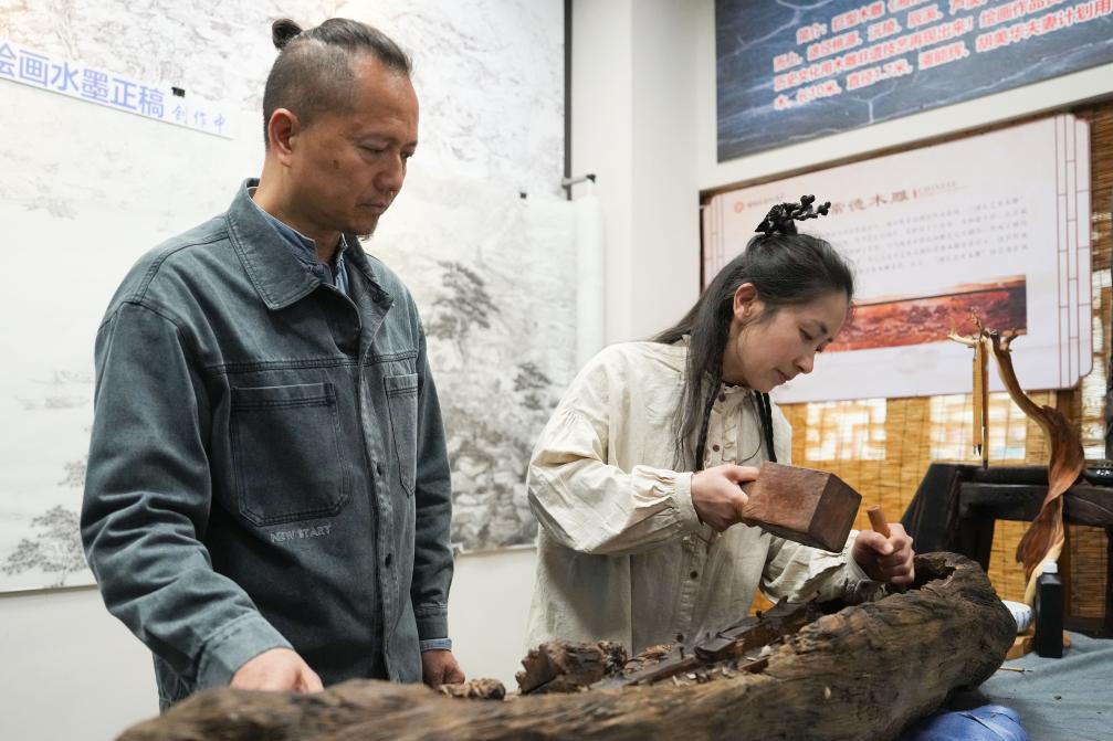 潘能輝和妻子胡美華在湖南常德河街展示木雕。新華社記者 薛宇舸 攝